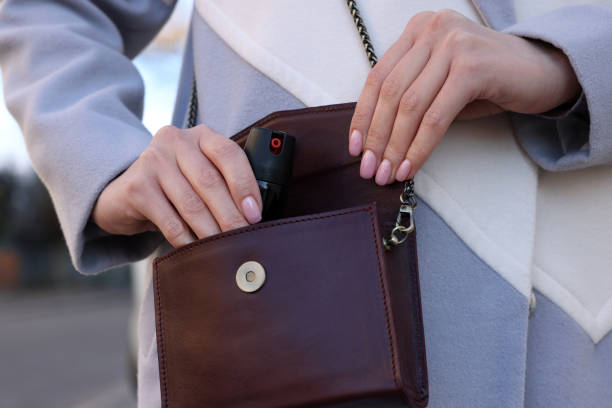 istock Young woman putting pepper spray into bag outdoors, closeup 1457064466