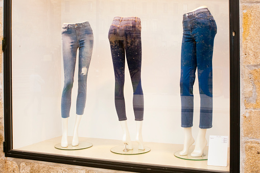 Mannequin legs, clothes store window, jeans, city life reflections. Pontevedra city, Galicia, Spain.