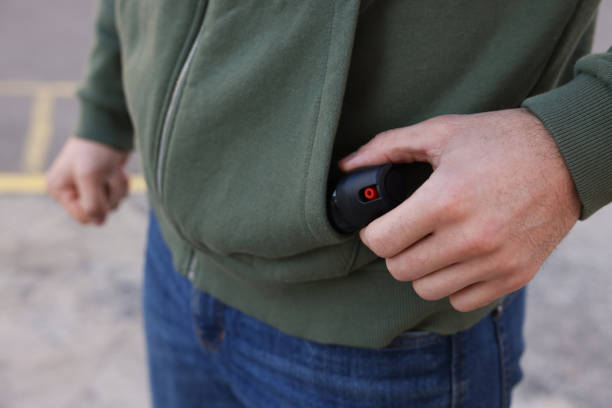 istock Man putting pepper spray into sweater pocket outdoors, closeup 1457066706