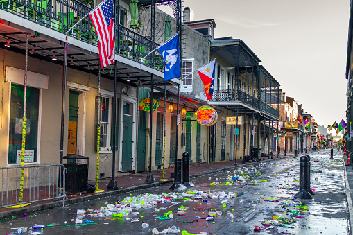 New Orleans, Louisiana, USA United States of America - March 1, 2022: Thousands of tons of garbage are thrown into the streets every day in the Carnival days. Here is an example of this in the French Quarter neighborhood.\n\nThe Mardi Gras is one of the emblematic events of this city that attracts millions of nationals and internationals tourists to the city during the days of the carnival.
