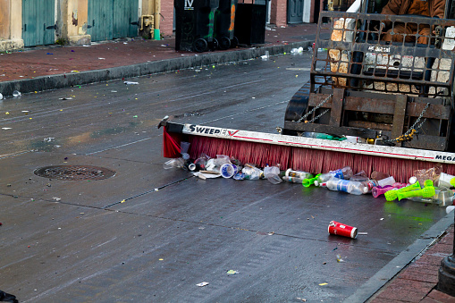 New Orleans, Louisiana, USA United States of America - March 1, 2022: A group of municipal employees working to clean and taking out thousands of tons of garbage are thrown into the streets every day in the Carnival days. Here is an example of this in the French Quarter neighborhood.\n\nThe Mardi Gras is one of the emblematic events of this city that attracts millions of nationals and internationals tourists to the city during the days of the carnival.