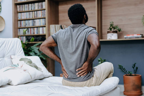man wakes up with back pain - dor de costas imagens e fotografias de stock