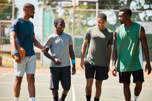 Team walking, basketball and conversation on sports court for fitness, healthy exercise workout and wellness training. Teamwork motivation, relax collaboration and group of people on basketball court