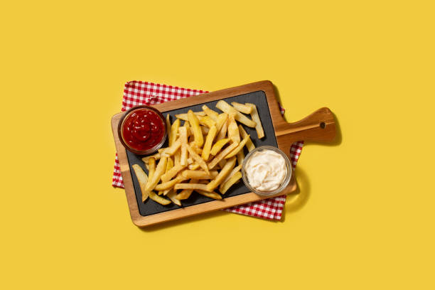 istock Fried potatoes with ketchup and Mayonnaise on yellow background 1457072556