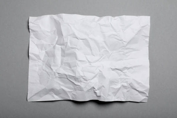 istock Sheet of white crumpled paper on grey background, top view 1457072631