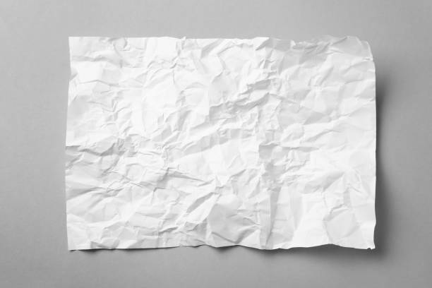 istock Sheet of white crumpled paper on grey background, top view 1457072878