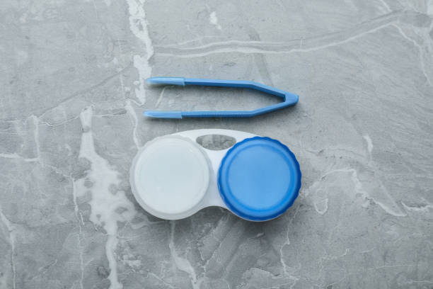 istock Case with contact lenses and tweezers on light grey marble table, flat lay 1457073544