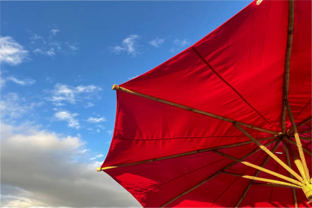 istock Beach Umbrella Against the Blue Morning Sky. Red Beach Umbrella 1457080512
