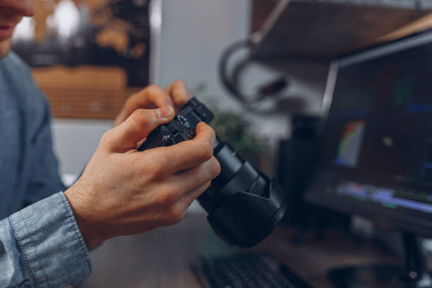 istock Crop man with professional photo camera in hands in home office 1457080598