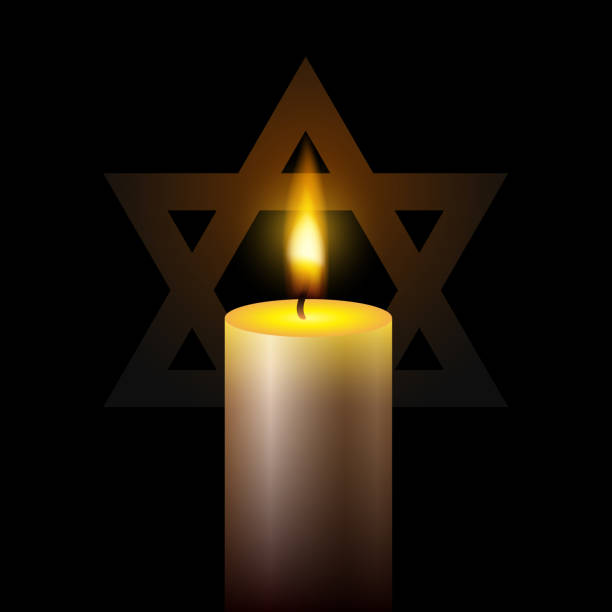 istock International holocaust remembrance day. One burning candle and star of David on black background. 1457082275