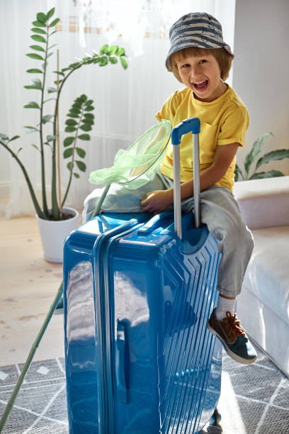 istock A child sitting on a suitcase have fun and laughs, waiting for a trip on vacation 1457082731