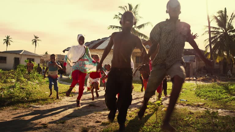 Group of African Little Children Running Towards the Camera and Laughing in Rural Village. Black Kids Full of Life and Joy Enjoying their Childhood and Playing Together. Little Faces with Big Smiles