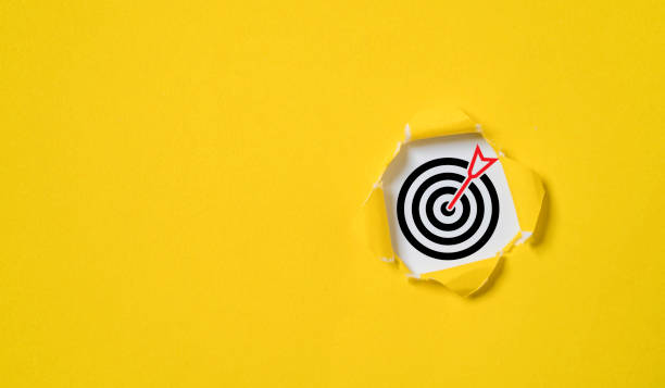 istock Dartboard with arrow inside of yellow punched paper for setup business objective target and goal concept. 1457084494