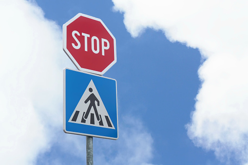 Stop and pedestrian crossing sign on a road