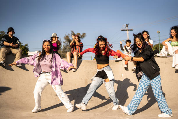 amigos bailando y divirtiéndose durante la fiesta callejera en el parque de patinetas - chilean ethnicity fotografías e imágenes de stock