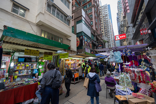 Hong Kong - January 17, 2023 : People at the street market in Wan Chai, Hong Kong. Many street vendors selling products on the road.