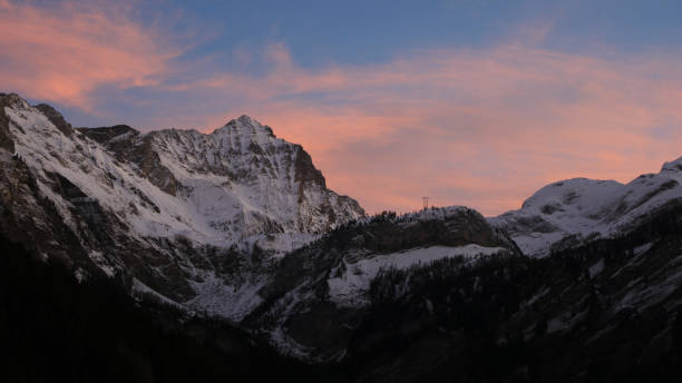 nuvole rosa illuminate dal sole sul monte arpelistock in inverno. - bernese oberland gstaad winter snow foto e immagini stock