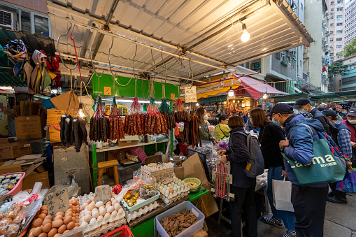 Hong Kong - January 17, 2023 : People at the Wan Chai Market in Hong Kong. The street is full of vendors selling fresh food.
