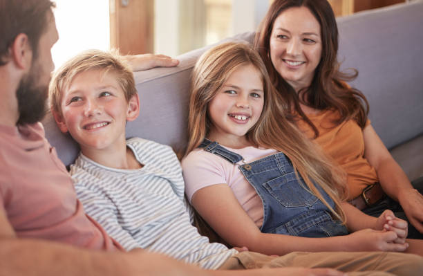 istock Relax, happy and smile with family on sofa for quality time, bonding and affectionate together. Weekend, rest and happiness with parents and children in living room at home for care, joy and content 1457089911