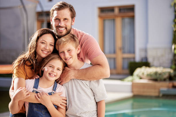 Happy family, relax outside house and outdoor with children, mom and dad smile with love by pool together. Portrait of mother, father and young kids hug together outside a modern home summer bonding familia feliz, relajarse fuera de la casa y retrato con los niños, mamá y papá sonríen con amor en la piscina juntos. al aire libre de la madre, el padre y los niños pequeños se abrazan juntos fuera de un hogar moderno de unión de verano