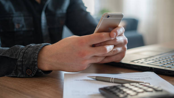 istock Close-up man texting by phone in home office 1457090028