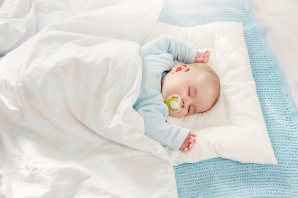 istock Cute three month old baby sleeping in comfortable bed. 1457091149
