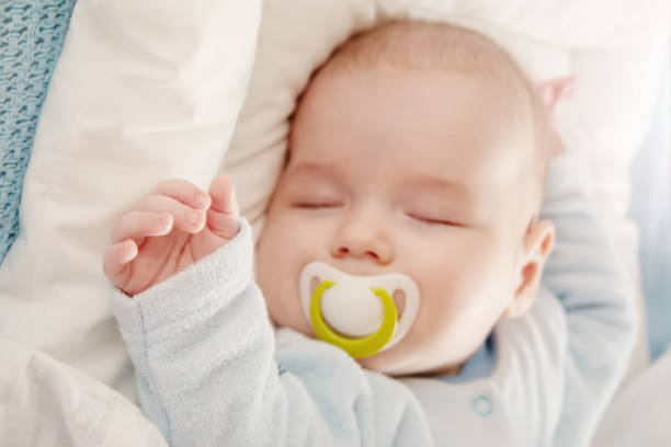 istock Cute three month old baby sleeping in comfortable bed. 1457091251