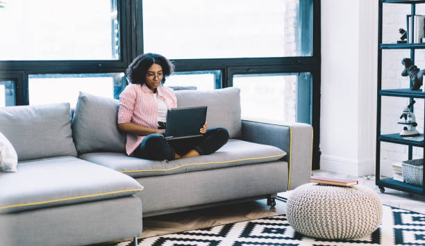 istock African American IT professional working remotely during weekend in cozy home apartment, skilled female freelancer searching website for making online banking and web booking via laptop application 1457091580