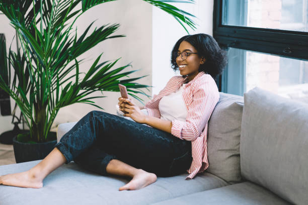 istock Cheerful dark skinned blogger checking received email on modern cellular gadget connecting to home internet for web networking, happy black female millennial browsing website for making booking 1457091614
