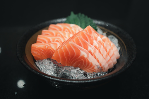 Salmon sashimi cutting fresh and raw pieces served on ice in a bowl, Japanese food style