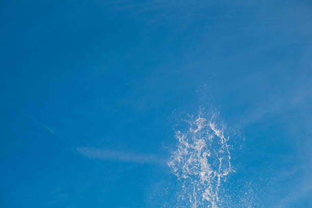 istock Water jet splashing and sparkling in bright sunny blue sky. 1457095067