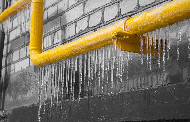 un tuyau glacé jaune avec du gaz sur le fond d’un mur gris. - givre eau glacée photos et images de collection