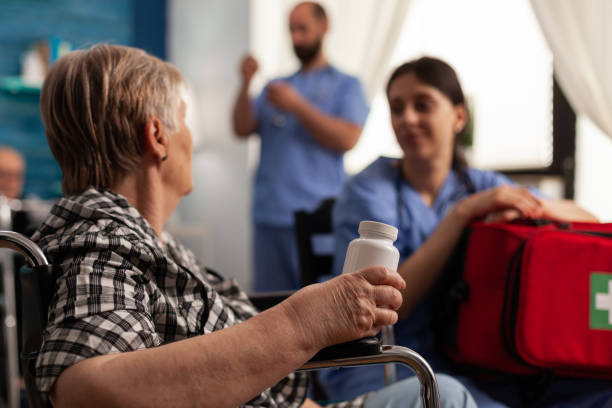 看護師と話す薬を持つ車椅子の引退した女性 - 4810 ストックフォトと画像