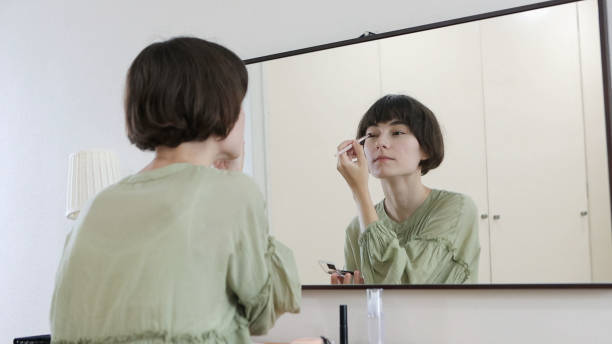 istock Young woman putting on makeup 1457101325