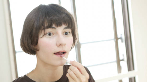 istock Young woman putting on makeup 1457101454