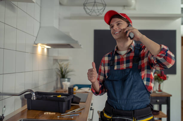 istock Plumber talking on the cellphone in a client kitchen 1457104991