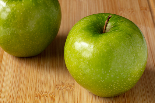 Two Granny Smith Apples on Cutting Board