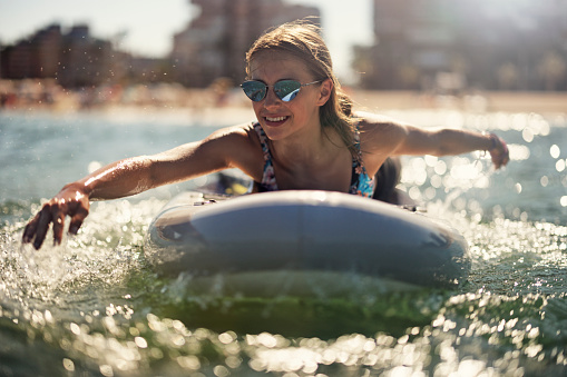 Teenage girl enjoying summer vacations. The girl is enjoying SUP paddleboard on the beach. Alicante, Spain.\nCanon R5