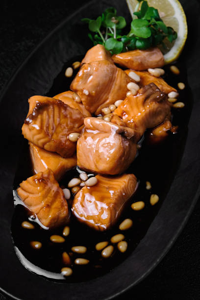 istock salmon in teriyaki sauce with pine nuts and lemon on black background 1457109009