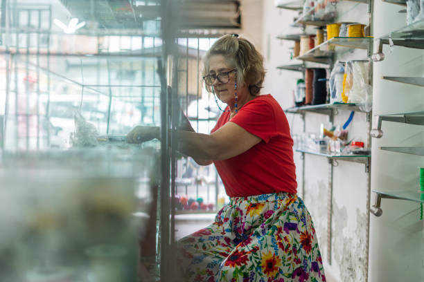 istock Latina woman is inside her sewing workshop checking all the buttons and utensils that she has in her workshop 1457110094