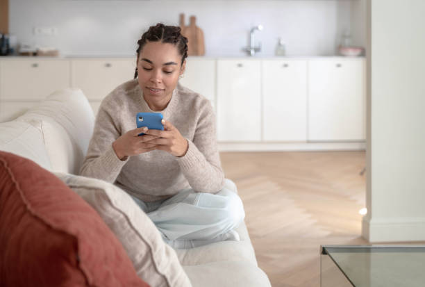 istock Woman using smartphone at home 1457116533
