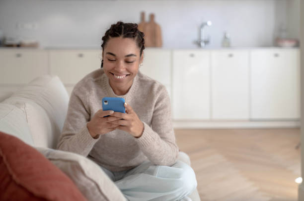 istock Woman using smartphone at home 1457116541