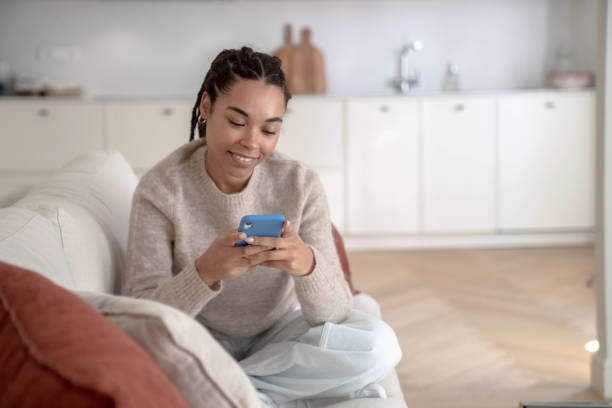 istock Woman using smartphone at home 1457116557