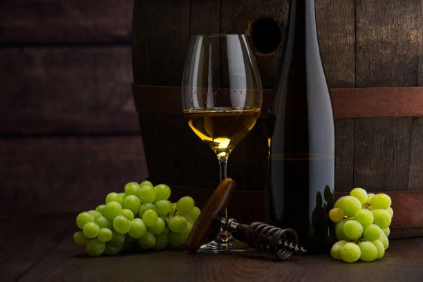 istock white wine bottle and wine glass on wodden barrel 1457120708