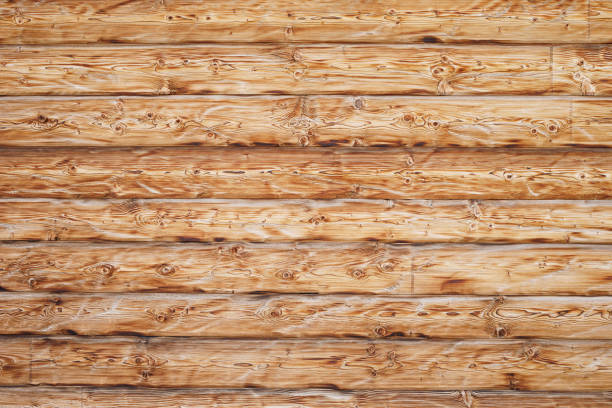 Brown wooden background texture highlighting the wood grain. Natural rustic surface comprising of slats of lumber.