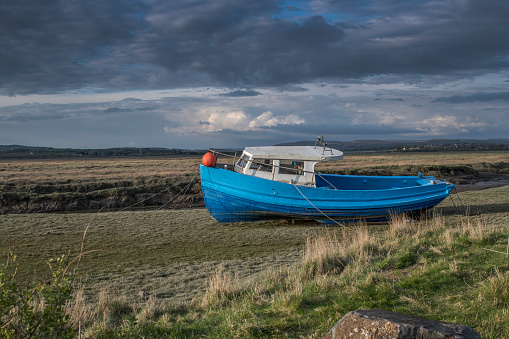 Old fishing boat at  river loughor estuary in the Gower South Wales waiting for the tide to come in