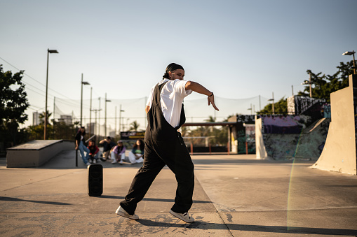 Mid adult man dancing hip hop at skateboard park
