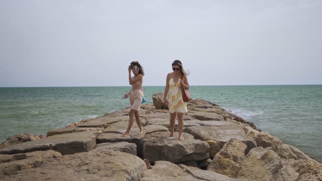 Women walking on the beach rocks
