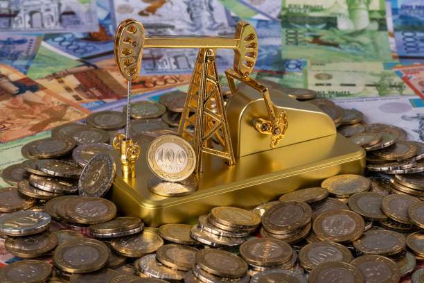 Oil pump, Kazakh coins in denominations of 100 and 200 tenge against the background of Kazakh banknotes Oil pump, Kazakh coins in denominations of 100 and 200 tenge against the background of Kazakh banknotes gold ira rollover guide stock pictures, royalty-free photos & images