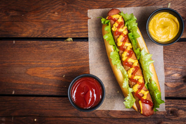 istock Fresh Hot Dog on Wooden Background 1457130363